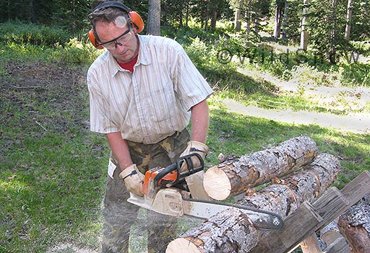 Backcountry skiing wood cutting for cabin.
