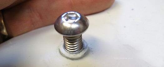 1/4 20 stainless machine screw in the T-nut. The white boss (rim) around the hole is removed for our bushing mod.