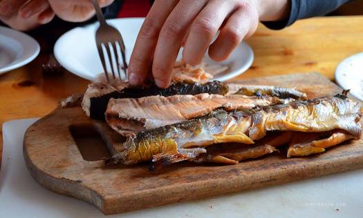 Beautiful pink flesh of freshly caught röding (arctic char) grilled over wood coals.
