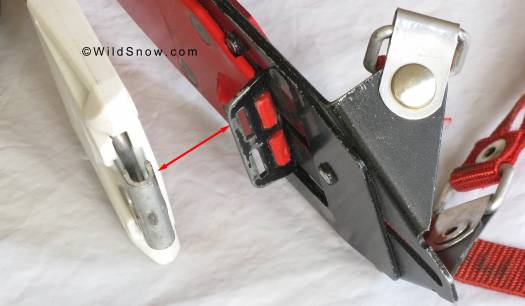 Loop of metal (left) slides in and out under spring tension, controlled by lever on heel fitting. The loop engages the slots visible to right, thus latching the plate down for skiing, and releasing it for touring. 