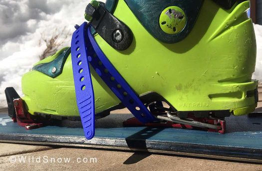 The ski strap threaded through the heel riser plate to fix the heel to the split-ski.