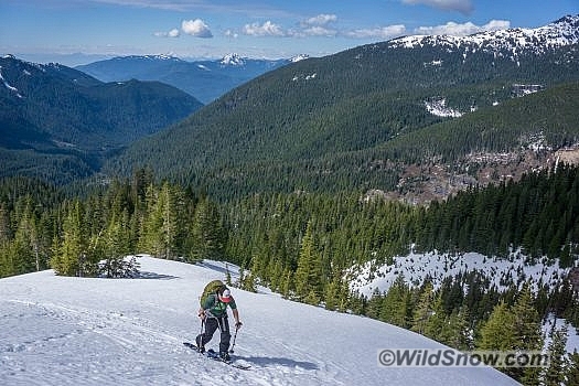 Mike skins up Hogsback Ridge with Canadian peaks in the background.