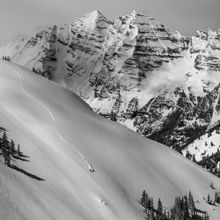 The same rules for Landscape photography apply to a landscape type ski photo. You should use a higher aperture to allow for sharpness throughout the entire image. For this image I manually pre-focused on the rocks just below the skier, made my composition and made sure to not move the camera as the skier descended the face. Camera: Canon 7dmkii w/ 70-200f2.8 at 1/1000, f9, ISO 320 at 85mm Skier: Andrew Benaquista