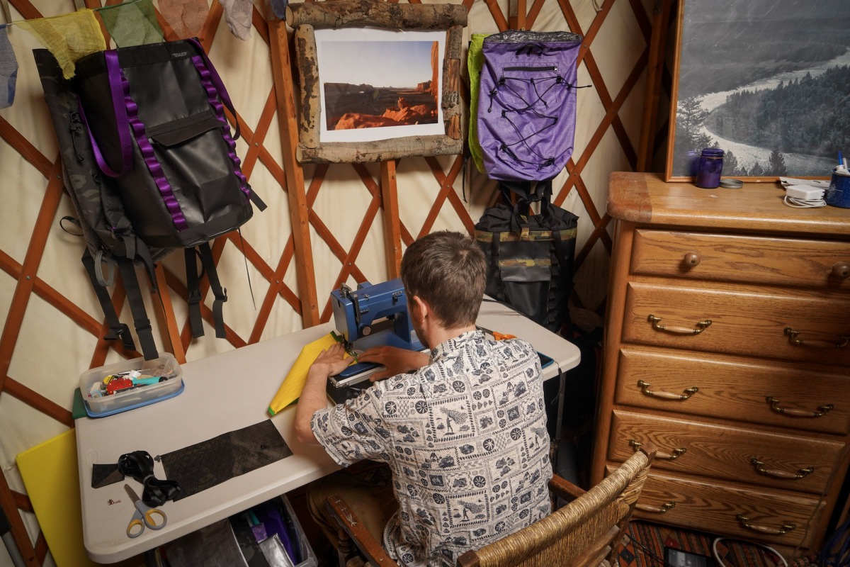 Gavin sewing together a fully custom Apocalypse Equipment SAC (Skiing And Climbing) in his yurt, on a ranch, in Jackson Wyoming, after a day of powder skiing / product testing, with the wood stove burning. Does it get more grassroots than that?