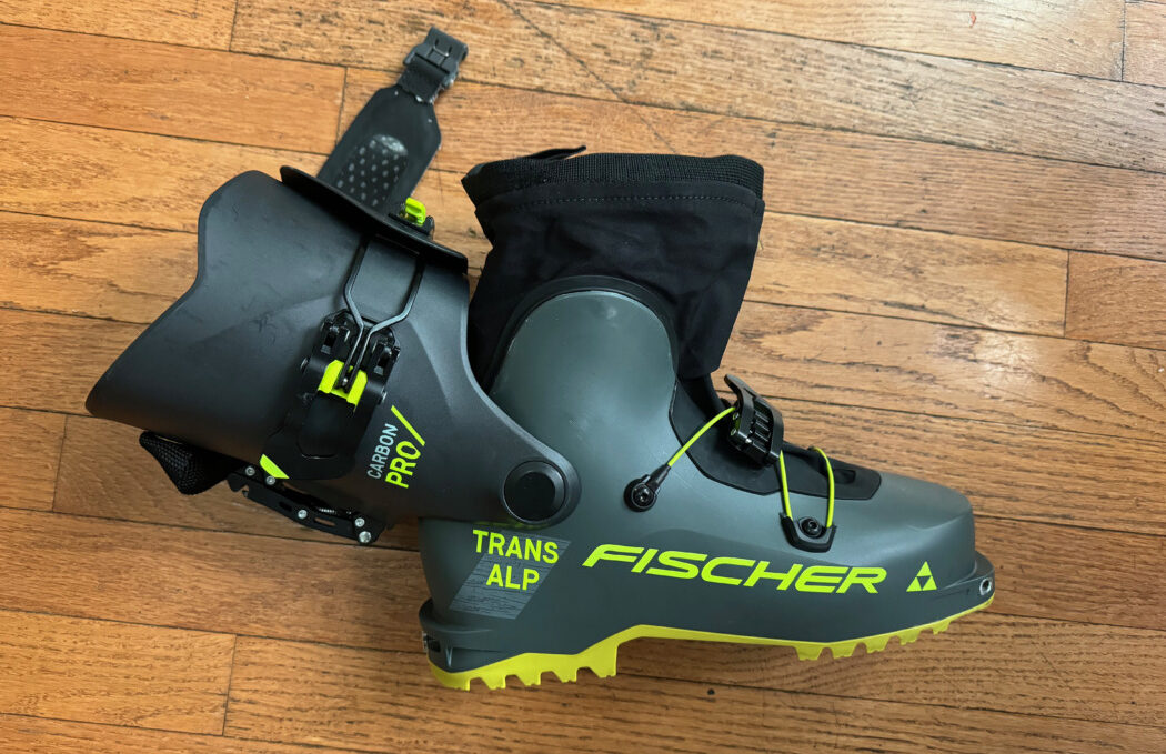 demonstrating the range of motion of the Fischer Transalp Carbon Pro boot by opening it at the hinge all the way back