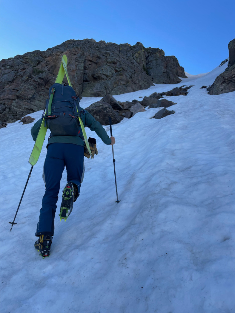 skiers climbing a steep slope wearing crampons on La Sportiva Skorpius II boots with skis on his back 