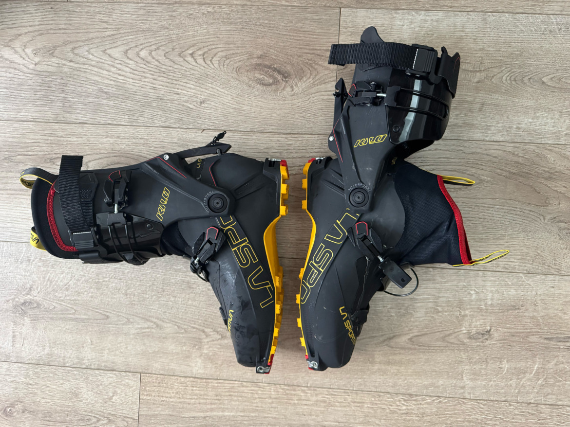 La Sportiva Kilo backcountry ski boots on wood floor with one boot fully articulated open