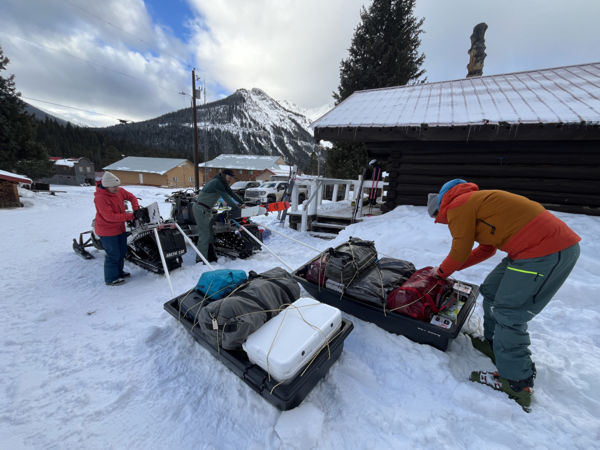 Skiers loading pulks with gear for hut trip