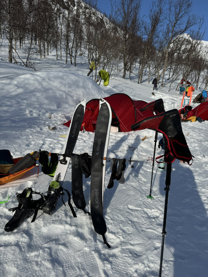 gear drying in the sun on snow in Norway on a splitboarding expedition