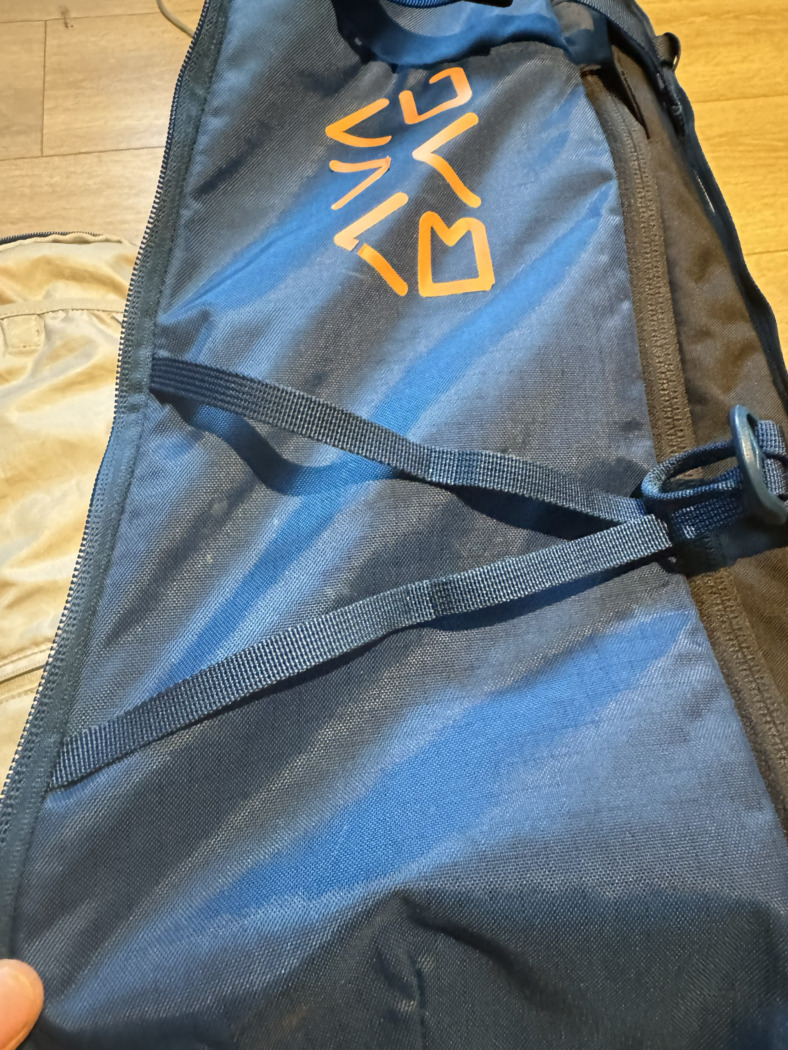 side of a ski backpack highlighting straps