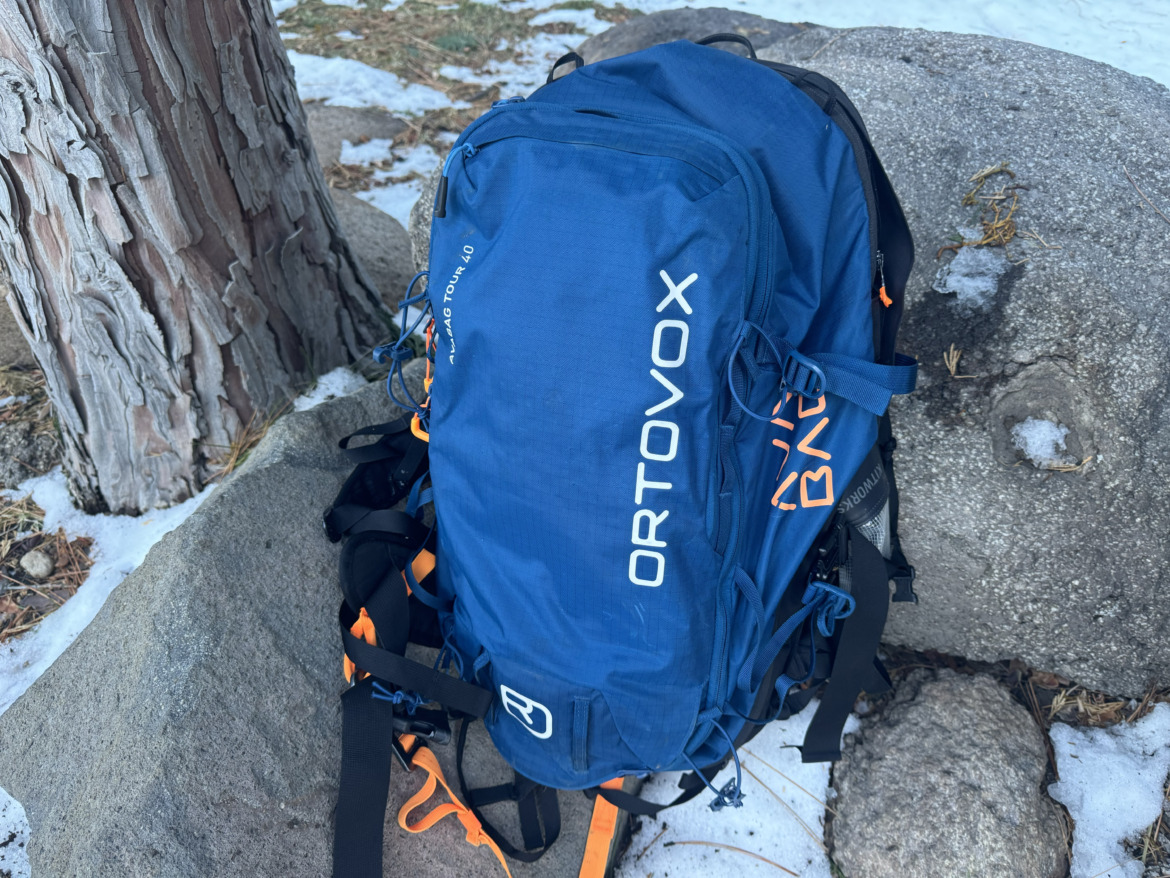 ski backpack sitting on rocks in the snow