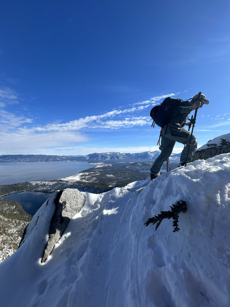 skier climbing on a ridge wearing a pack