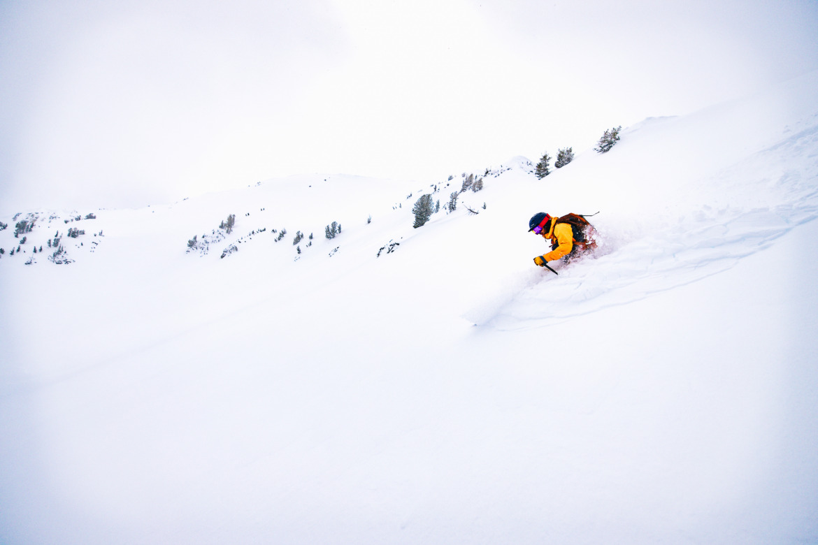 skier skiing away from the camera in soft powder snow